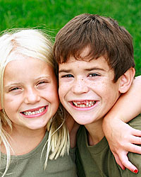 photo of two smiling young kids - a boy and a girl